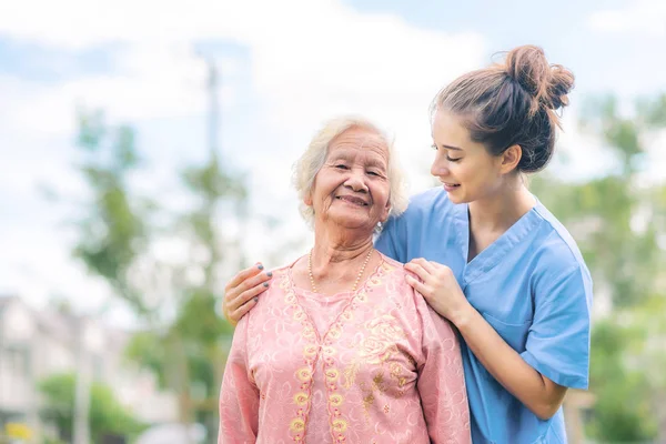 Nurse caregiver take care of Asian elderly woman in the park — 스톡 사진