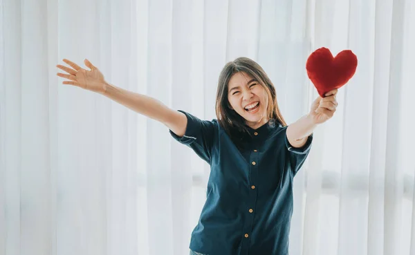 Mosolygó ázsiai nő mutatja piros szív tárt karokkal — Stock Fotó