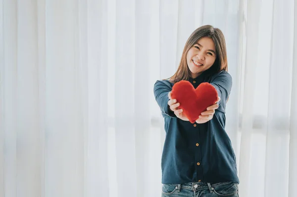 Mosolygós ázsiai nő mutatja piros szív — Stock Fotó