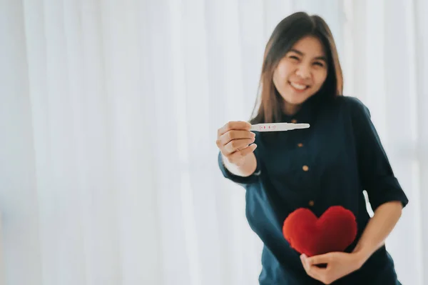Lövés a terhességi teszt pozitív eredménnyel mosolygó nő i — Stock Fotó