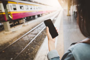 Tren istasyonunda akıllı telefon kullanan kadın yolcuların arka planı