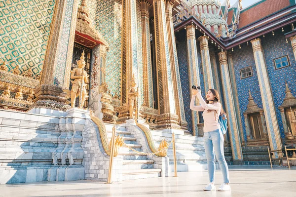 位于泰国曼谷的著名旅游胜地Wat Phra Kaew的翡翠佛寺内 快乐的亚洲女人带着相机观光 — 图库照片