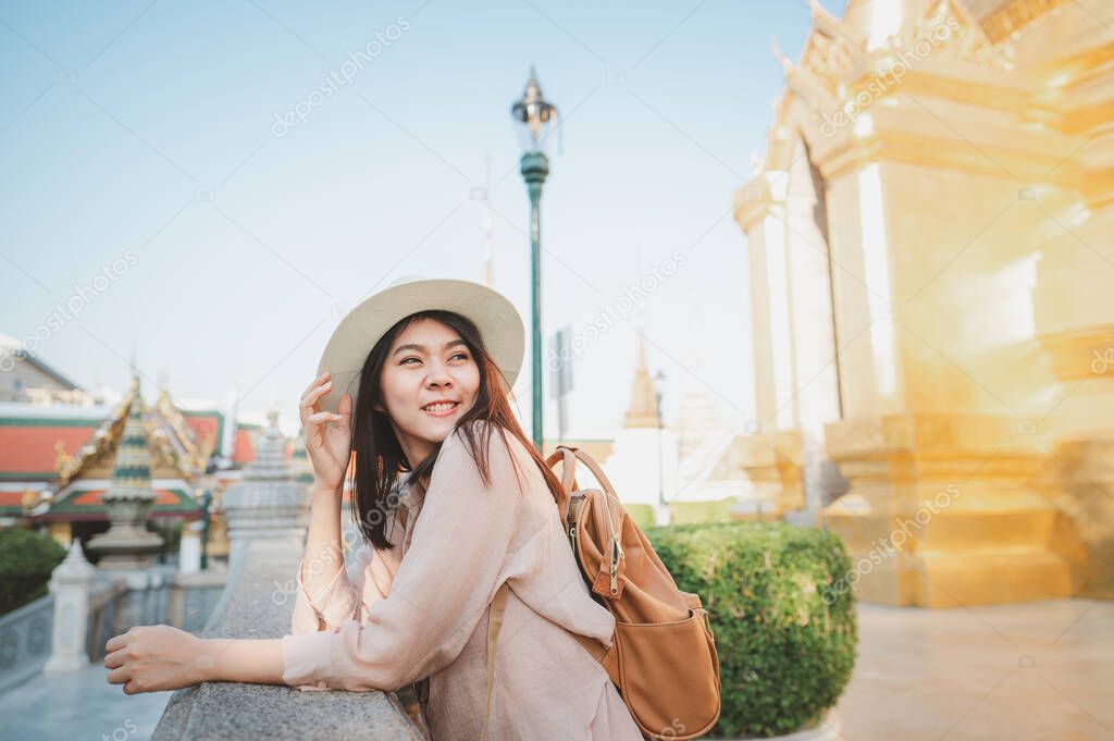 Asian women enjoy sightseeing while travel in temple of the emerald buddha, Wat Phra Kaew, popular tourist place in Bangkok, Thailand