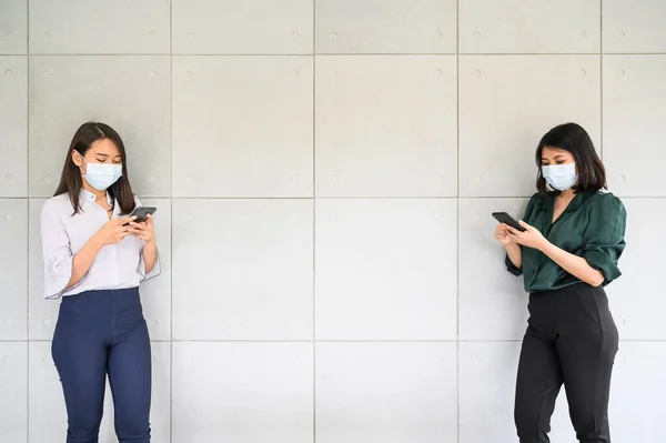 Duas Mulheres Asiáticas Usando Máscara Facial Usando Smartphone Manter Distanciamento — Fotografia de Stock