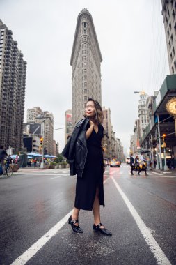 New York'un Manhattan Giyim deri ceket ve siyah elbise karşıya moda Asyalı kadın. Tarafına arayan kadın.