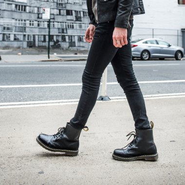 Erkekler moda kavramı. Adam giymek şık deri çizmeler ve açık havada yürümek siyah.