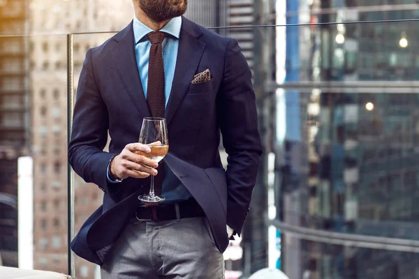 Foto conceptual de la vida de lujo de la gente rica. Adulto exitoso hombre de negocios elegante con traje y beber vino en la azotea en ático de lujo en la ciudad de Nueva York . — Foto de Stock