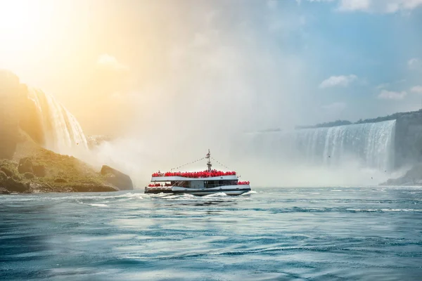 Cataratas del Niágara excursiones en barco atracción. Gente turística navegando en el barco de viaje cerca del Niágara Horseshoe Fall en el soleado y caluroso día de verano . — Foto de Stock