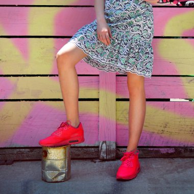 Kırmızı spor ayakkabılar ve gündelik elbise ile moda sokak stil kadın kıyafeti.