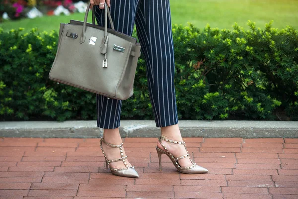Businesswoman summer outfit for office. Fashionable woman wear high hells shoes, blue cotton pants with white stripes and hold grey bag outdoors. — Stock Photo, Image