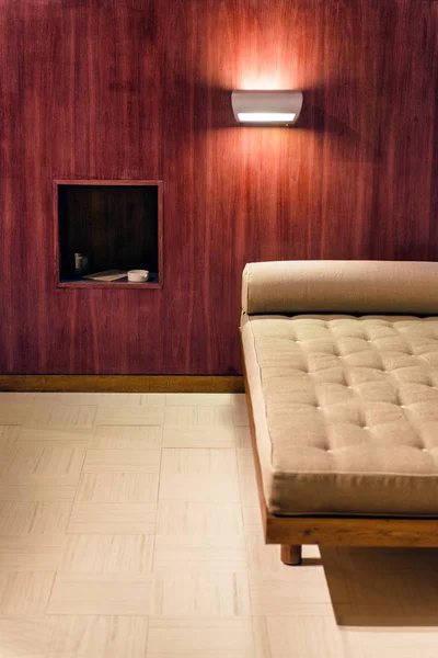 Interior del dormitorio con diseño minimalista. Sofá cerca de la pared de madera roja . — Foto de Stock