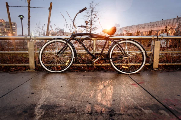 Retro style vintage bicycle locked by the fence on city street in the old town. Old charming bicycle concept — Stock Photo, Image