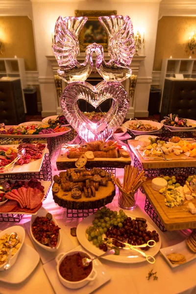 Buffettisch mit Eisskulptur im Restaurant bei Hochzeitsfeier — Stockfoto