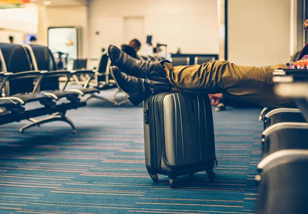 Reizigerskilometers met draagtasje van bagage te wachten voor de vertraging vlucht in de terminal van de luchthaven en ontspannen. — Stockfoto