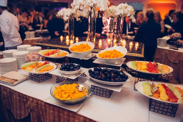 Auténtico buffet surtido de frutas frescas en platos durante el evento con la gente. Servicio de catering —  Fotos de Stock