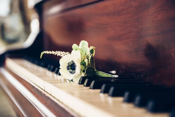 Hochzeitstag. boutonniere Blume für den Bräutigam auf den Klaviertasten. — Stockfoto
