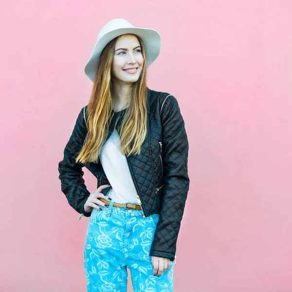 Jovem feliz moda blogger menina posando perto da parede vestindo roupas de rua casual estilo. Estilo de vida foto de mulher bonita usando chapéu e olhando para o lado sorrindo . — Fotografia de Stock