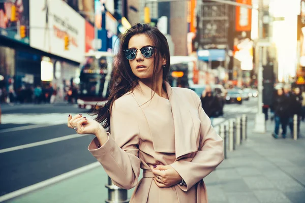 Modieuze meisje lopen op New York City street in Midtown dragen zonnebril en ping jas. — Stockfoto