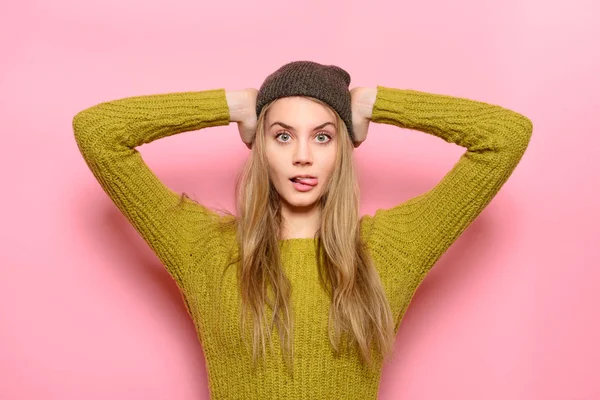 Exited Hipster girl having fun showing tongue wearing casual outfit posing near pink wall — Stock Photo, Image