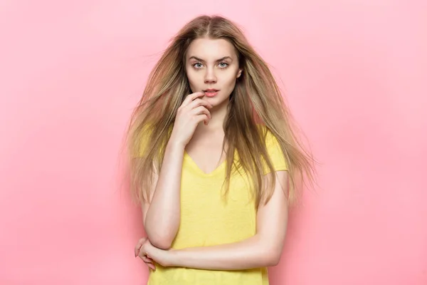 Mulher bonita com rosto perfeito e maquiagem natural posando contra a parede rosa vestindo camiseta casual . — Fotografia de Stock