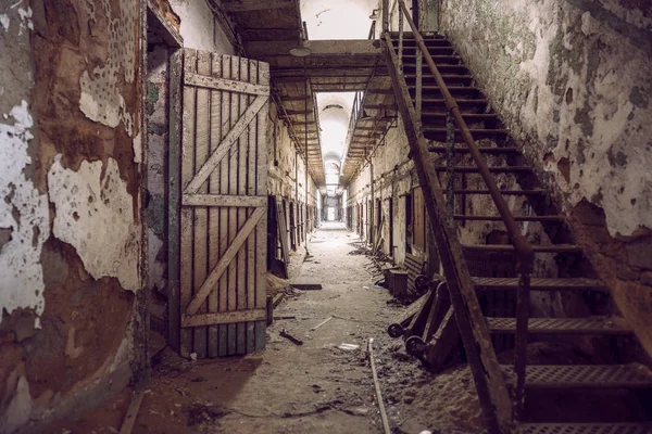 Övergiven fängelse cell gångväg med gamla rostiga trappor, dörrar och peeling väggar. Philadelphia Eastern State Penitentiary. — Stockfoto