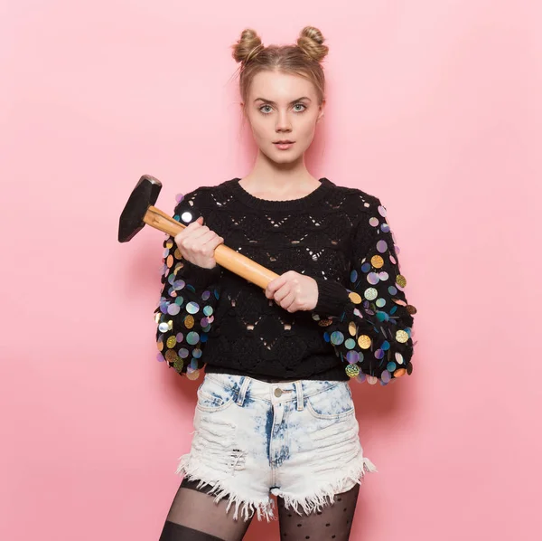 Beautiful cute girl holding heavy hammer in hands. Home repair and feminism concept. — Stock Photo, Image