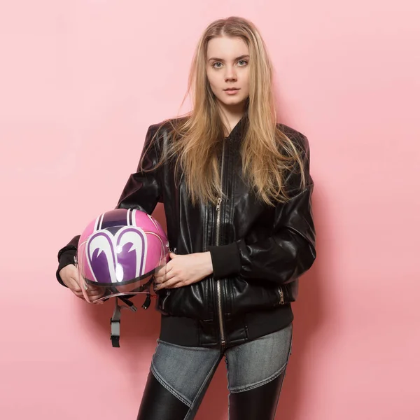 Biker girl wearing black leather jacket holding pink motorcycle helmet. — Stock Photo, Image