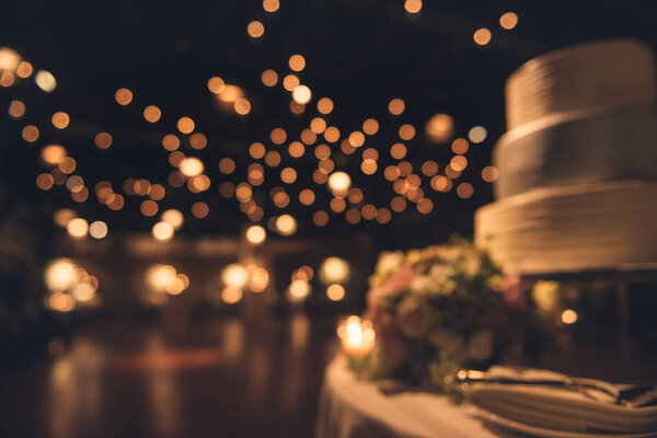 Wedding party evening. Blurred dance floor and wedding cake. Wedding invitation background.