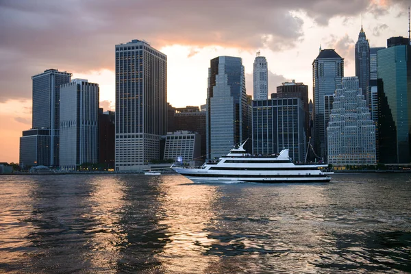 New York City Skyline bei Sonnenuntergang und Kreuzfahrtschiff mit Touristen. — Stockfoto