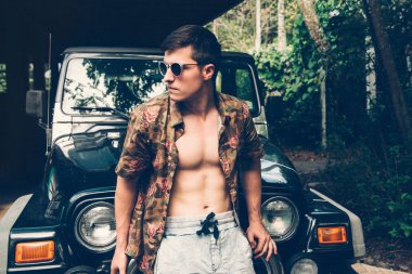 Yakışıklı adam arabanın içinde tropikal orman tarafından sıcak yaz gününde, beraber seyahat. İnsanlar seyahat ve Turizm kavramı.