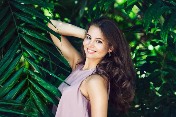 美しい笑顔の女性は、自然の緑の熱帯林の背景にポーズします。自然の美しさと女性のヘルスケアの概念. — ストック写真