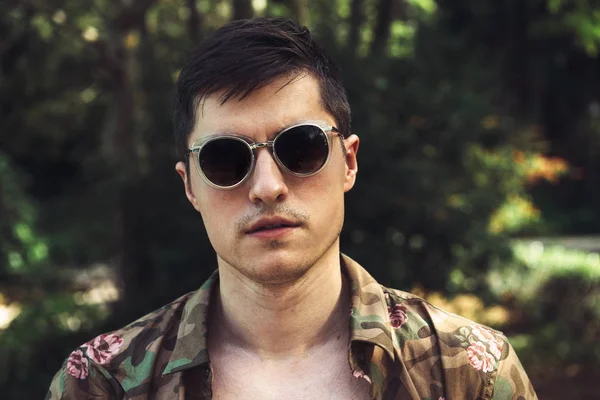 Bonito homem usando óculos de sol e camiseta nas férias de verão — Fotografia de Stock