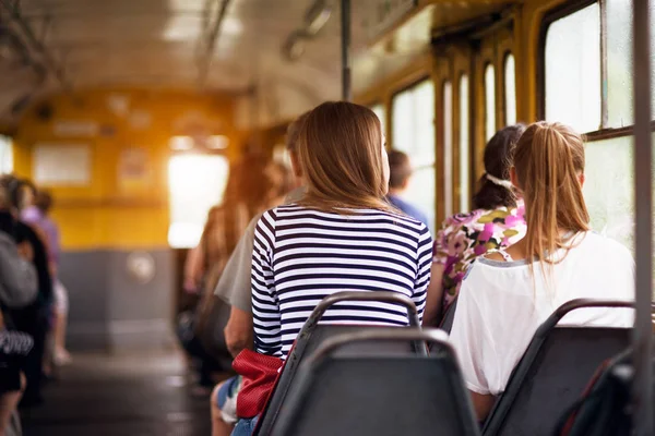 Student women taking a ride in public transport from the work at sunset time — Stock Photo, Image