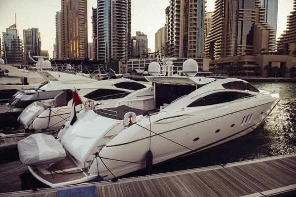 Luxusjachtok parkolt a mólón, a Dubai Marina bay a városra néző kilátással. — Stock Fotó
