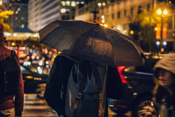 Un om mergând cu umbrela pe strada orașului pe timp de noapte ploios de la locul de muncă — Fotografie, imagine de stoc