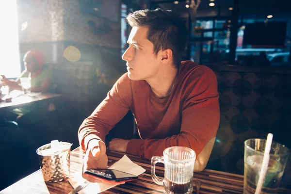 Muž s ranní snídani s kávou v restauraci café a pomocí svého mobilního telefonu — Stock fotografie