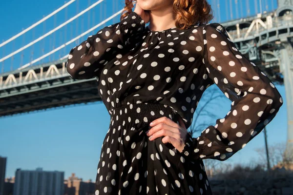 女性の身に着けている黒と白の水玉ドレス都市の屋外でポーズ — ストック写真
