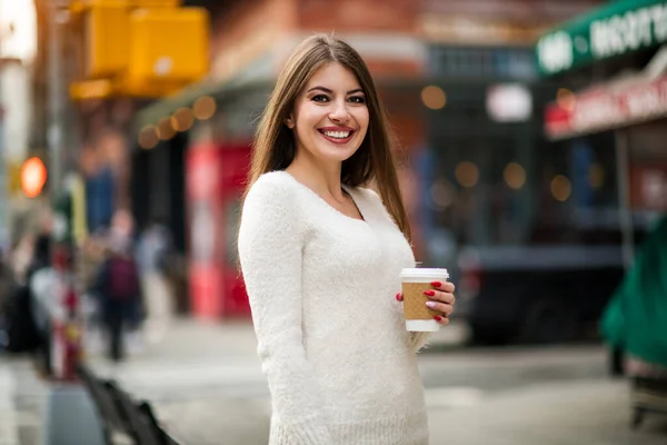自然の笑顔を持つ美しい女性は屋外でコーヒーを飲む街で彼女の一日をお楽しみください — ストック写真