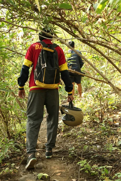Dois jovens caminhando na selva tropical com mochila. Caminhante masculino com mochila caminhando ao longo da trilha florestal . — Fotografia de Stock