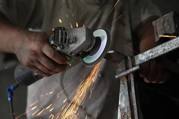 Metal işleri. Fabrikada çelik yapısı üzerinde taşlama elektrikli tekerlekli