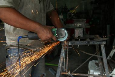 Metal işleri. Fabrikada çelik yapısı üzerinde taşlama elektrikli tekerlekli