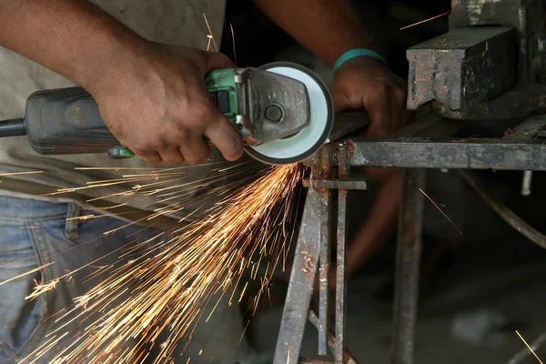 Metal works. Electric wheel grinding on steel structure in factory