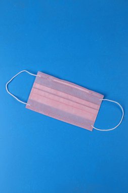 Covid-19 geçmişi. Salgın arka planda. Yığının içindeki yüz maskesi. Karantina geçmişi. Sağlık sigortası geçmişi. Pembe tek kullanımlık yüz maskesi ve covid-19 parmak izi. Yığınla yüz maskesi toptancısı.