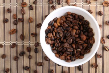 Taş zeminde kahve çekirdekleri ve kase. Metnin için kopyalama alanı olan üst görünüm