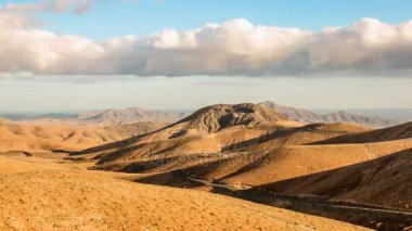 Kuru üzerinde uçan Timelapse bulutlar dağlar ve pürüzsüz hills, Fuerteventura, İspanya
