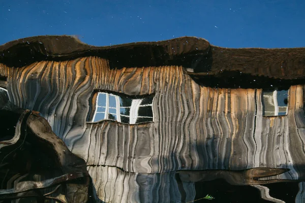Réflexion d'une maison en bois sur la surface de l'eau — Photo