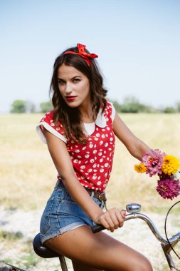 Genç pinup kadın alanlar'ın altında parlak mavi yaz gökyüzü uzay resmi Kopyala Bisiklete binme