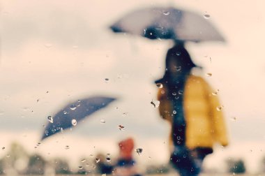 Anne ve oğlu açık şemsiye siluet ıslak pencereden altında