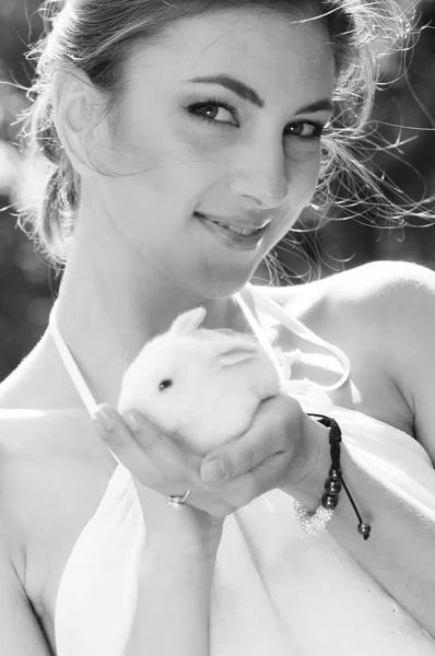 黑白图象微笑的妇女拿着一只逗人喜爱的白色兔子兔子 — 图库照片