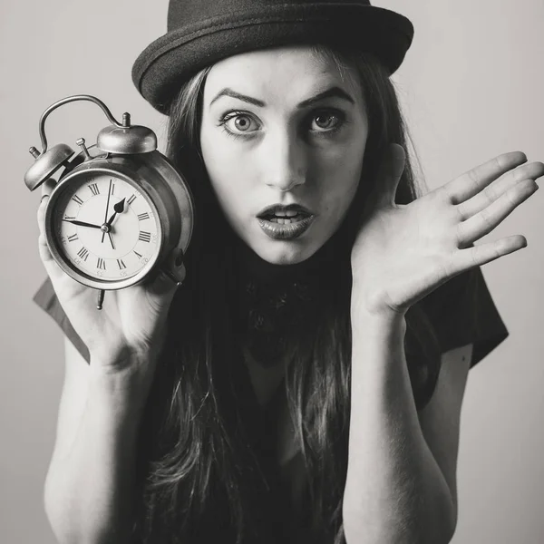 黑白肖像优雅美丽的年轻女士在帽子上显示闹钟 并在相机中寻找 — 图库照片